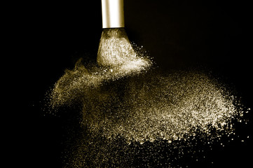 gold powder splash and brush for makeup artist or beauty blogger in black background, look like a lu