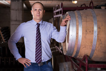 Canvas Print - Winemaker standing in wine cellar