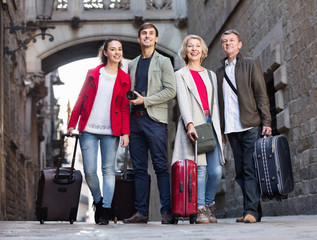 Happy family of four with trunks and bags