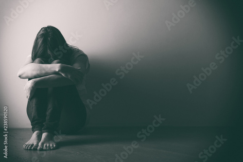 Fotografía Teenager girl with depression sitting alone on the floor in the dark room