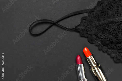 Fotomural Black lace bra underwear, red lipstick on dark background top view flat lay