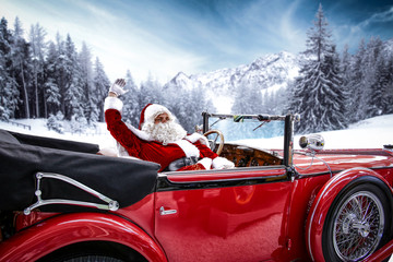 Santa claus in a red car on Christmas Eve evening  