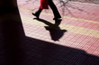 Blurry silhouette and shadow of a person on a city sidewalk