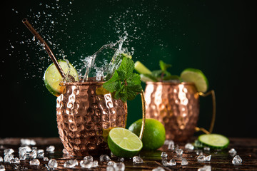 Famous splashing Moscow mule alcoholic cocktail in copper mugs.