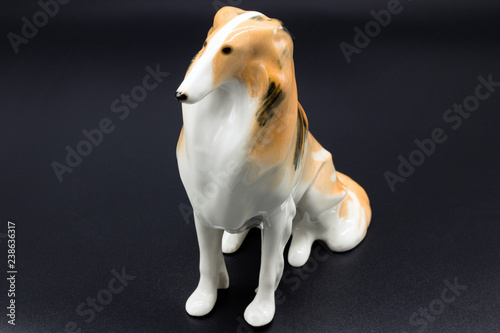 Fotografie, Obraz Antique porcelain figurine of a dog Collie breed on the black background