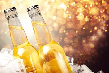 Bottles of beer in ice on blurred background