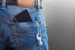 © Iana Alter - Smartphone with headphones in back pocket of men jeans. copy space. lifestyle concept
