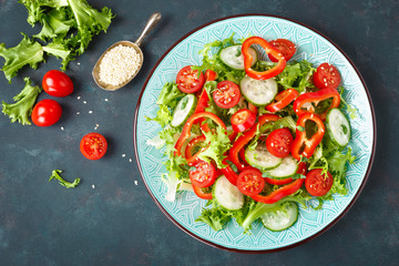 Healthy vegetarian vegetable salad of fresh lettuce, cucumber, sweet pepper and tomatoes. Vegan plant-based food. Flat Lay. Top view