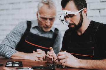 Wall Mural - Two Men Repairing Hardware Equipment in Workshop.