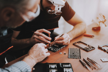 Wall Mural - Two Men Repairing Hardware Equipment in Workshop.