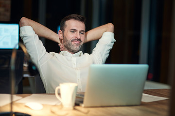 Satisfied man resting in his office