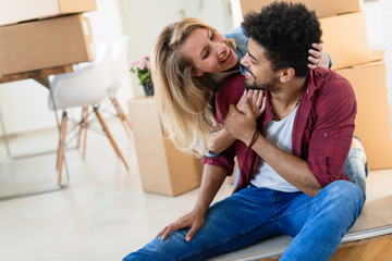 Wall Mural - Young couple unpacking cardboard boxes at new home moving in concept