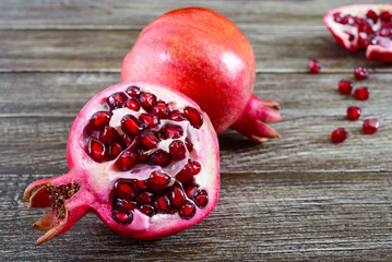Wall Mural - Ripe pomegranate fruit for making fresh pomegranate juice on wooden table. Healthy eating concept.