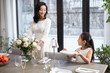 © Blue Jean Images - Mother and daughter setting the table