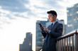 © Blue Jean Images - Young businessman using smartphone outdoors