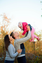 Wall Mural - The family in the park. Happy parents with children walk