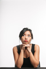 Wall Mural - Pensive young asian woman sitting at the table