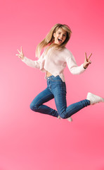 Wall Mural - Full length of a cheerful girl wearing sweater jumping