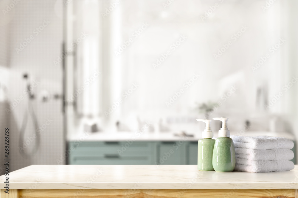 Ceramic shampoo, soap bottle and towels on counter over bathroom background. table top and copy space - obrazy, fototapety, plakaty 