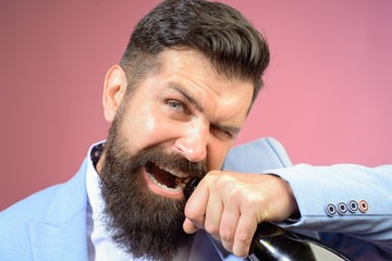 Brutal handsome man opens his teeth bottle of champagne. Champagne or wine bottle. Sexy male model pulls out cork with teeth with bottle of wine. Bearded man trying to open bottle of wine. Bad habits.