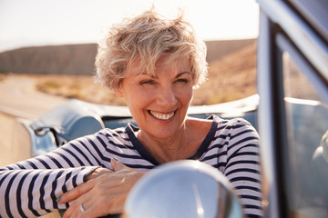 Senior woman in front passenger seat of open car, close up