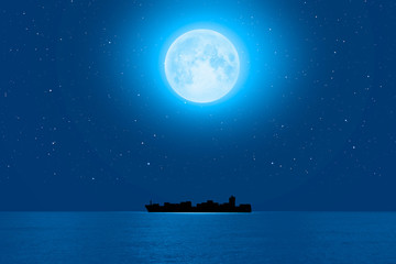 Wall Mural - Silhouette of the cargo ship with super full moon (moonrise) 