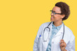 Young african american doctor woman wearing medical coat over isolated background looking away to side with smile on face, natural expression. Laughing confident.