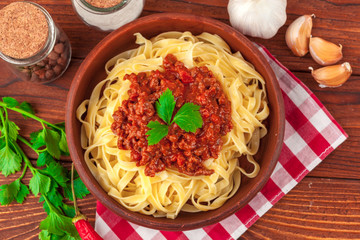 Pasta with meat, tomato sauce and vegetables on the table