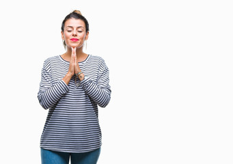 Poster - Young beautiful woman casual stripes sweater over isolated background praying with hands together asking for forgiveness smiling confident.