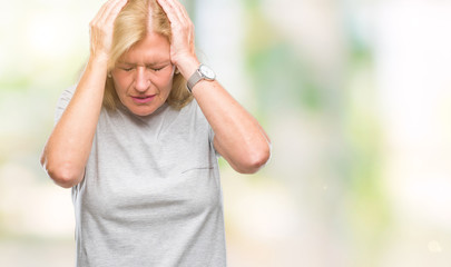 Canvas Print - Middle age blonde woman over isolated background suffering from headache desperate and stressed because pain and migraine. Hands on head.