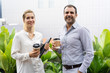 © Mangostar - Happy successful business colleagues enjoying coffee break. Business man and woman drinking takeaway coffee outdoors. Work balance concept