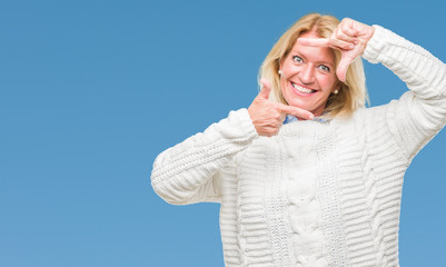 Canvas Print - Middle age blonde woman wearing winter sweater over isolated background smiling making frame with hands and fingers with happy face. Creativity and photography concept.