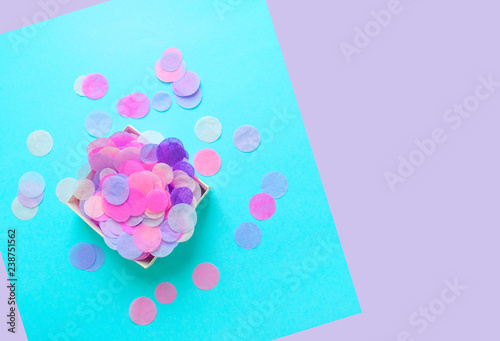 Fotografie, Obraz Top view of box full of colorful confetti on pastel blue and violet background with copyspace