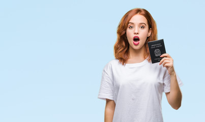 Wall Mural - Young beautiful woman holding passport of italy over isolated background scared in shock with a surprise face, afraid and excited with fear expression