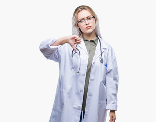 Wall Mural - Young blonde doctor woman over isolated background looking unhappy and angry showing rejection and negative with thumbs down gesture. Bad expression.