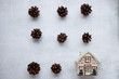 holidays, winter and celebration concept - Christmas composition. pine cones, toy house on cement background. Flat lay, top view