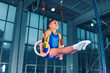 © master1305 - Full length shot of male athlete performing pull-ups on gymnastic rings. Fitness boy with strong body exercising at gym. The performance, sport, acrobat, acrobatic, exercise, training concept