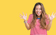 © Krakenimages.com - Young beautiful brunette woman wearing stripes t-shirt over isolated background celebrating crazy and amazed for success with arms raised and open eyes screaming excited. Winner concept