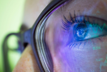 businesswoman in glasses, the reflection in the glasses graphs, tables, sale