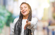 © Krakenimages.com - Young braided hair african american girl wearing sweater over isolated background smiling friendly offering handshake as greeting and welcoming. Successful business.