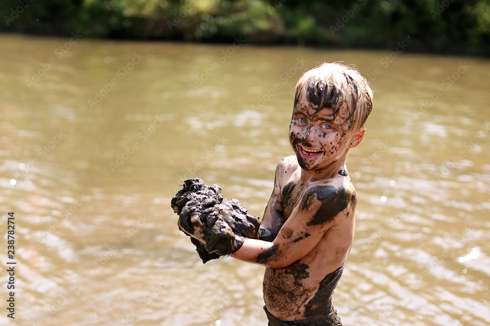 Muddy Little Boy Child Laughing as He Swims and Plays Outside in River