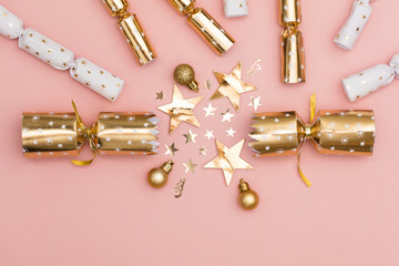 Wall Mural - Christmas crackers. luxury gold festive cracker on a pastel pink background