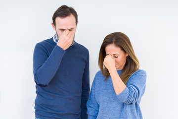 Wall Mural - Beautiful middle age couple in love over isolated background tired rubbing nose and eyes feeling fatigue and headache. Stress and frustration concept.