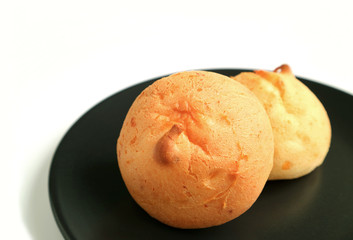 Pair of Delicious Pao de Queijo or Brazilian Cheese Breads on Black Plate Isolated on White Background 