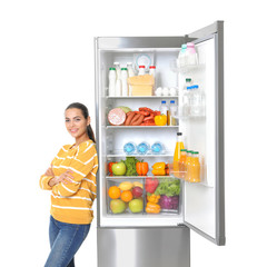 Wall Mural - Young woman near open refrigerator on white background