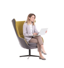 Young businesswoman with laptop sitting in armchair on white background