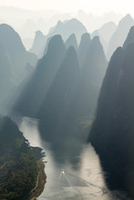 Karst Limestone Hills In Silhouette At Sunrise Over Li River As Seen From Xianggong Mountain, Near Guilin, China. Sun Rays Shining Between Hills.
