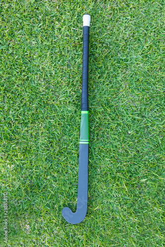 Fototapeta na szkło Field Hockey stick on green grass