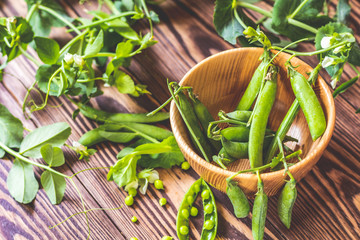 Wall Mural - Pods of green peas and pea on dark wooden surface