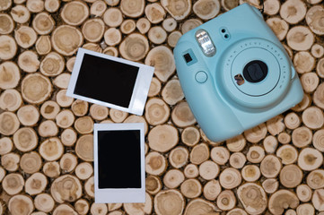 instant camera and photos on wooden background